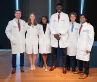 Photo of the six year one residents wearing white lab coats.